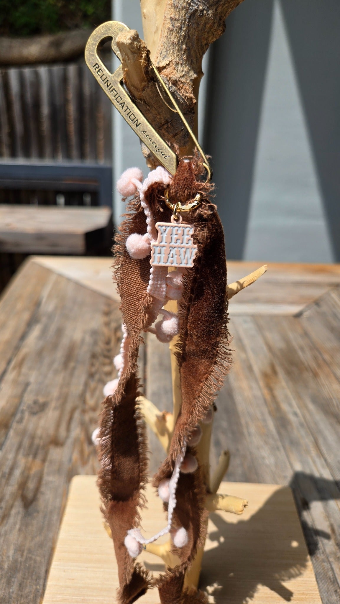 Brown ribbon charm with pink details and western pin