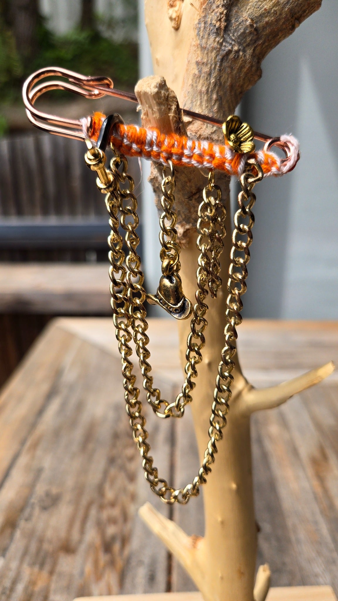 Orange wrapped gold chain accessory with cowboy hat charm